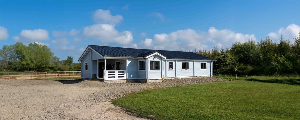 3 bedroom log house with a gravel path and grass