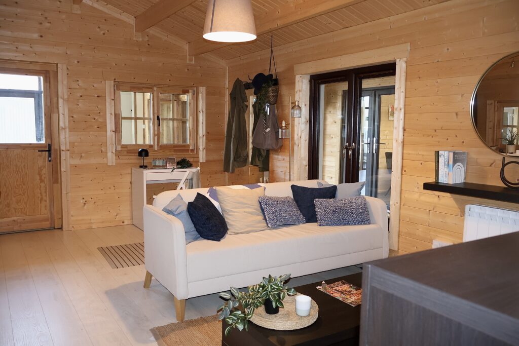 Open plan log cabin interior Ireland with living and dining area in timber finish